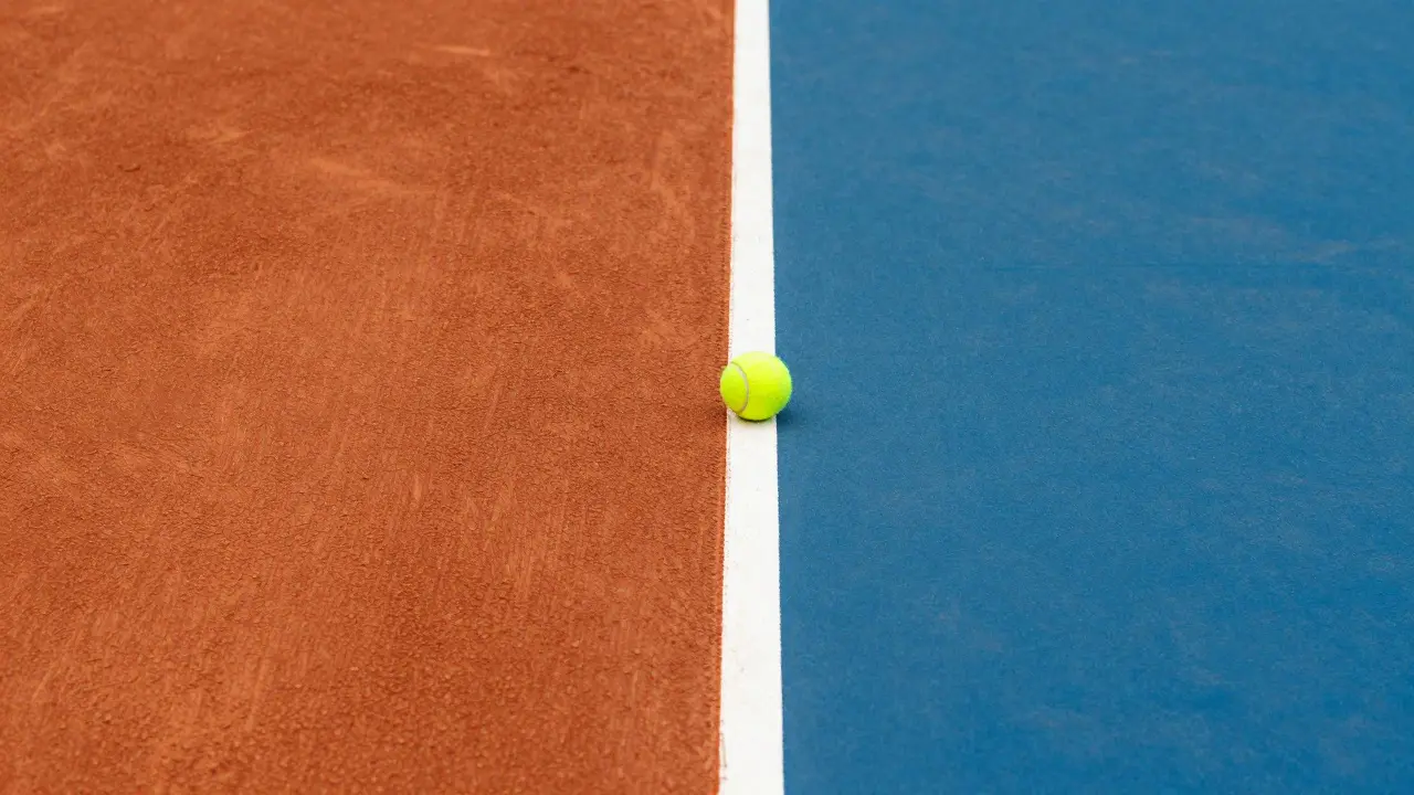 Detailní pohled na rozdíl mezi antukovým a tvrdým povrchem tenisového kurtu.